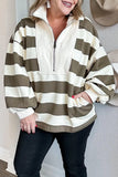 A woman wearing a cream and olive green horizontally striped quarter-zip pullover sweatshirt with a mock neck and front pockets, paired with black jeans.