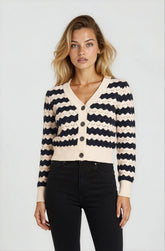 Woman wearing a black and white striped cardigan on a plain background