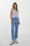 Woman wearing a light purple sleeveless top and blue jeans on a white background