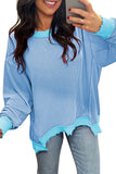 Woman wearing a blue ribbed sweater taking a selfie.