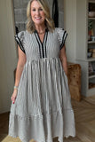 Woman wearing a black and white striped dress indoors.