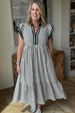 Woman wearing a black and white striped dress indoors.