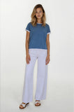 Woman wearing a blue t-shirt and white pants on a white background