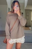 Woman wearing a brown off-shoulder sweater over a white lace dress, holding a phone with a floral case.