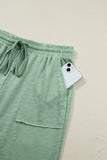 Green pants with a phone in the pocket on a beige background
