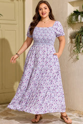 Woman wearing a floral dress standing outdoors with plants in the background