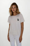 Woman wearing a light gray t-shirt with a logo on a white background