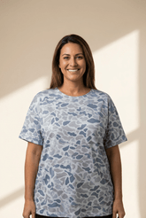 Woman wearing a blue patterned shirt against a neutral background