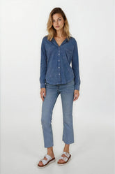 Woman wearing a blue shirt and jeans on a white background