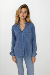 Woman wearing a blue denim shirt and jeans on a white background