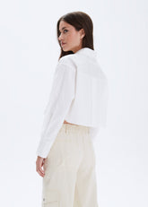Woman wearing a white blazer and beige pants on a white background