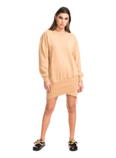 Woman wearing a beige sweatshirt dress on a white background