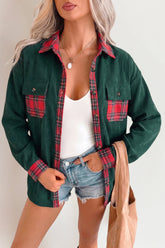 Woman wearing a dark green shirt jacket with red-black plaid accents, white tank top, and denim shorts.