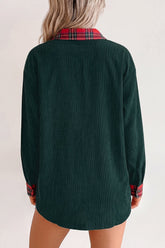 Woman wearing a dark green shirt with red-black plaid collar and cuffs.