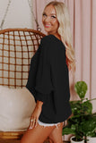 Woman wearing a black outfit with a pink background and plant
