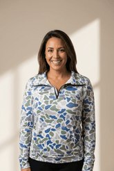 Woman wearing a patterned long-sleeve shirt against a neutral background