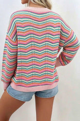 Woman in pink, orange, green and blue chevron-striped knit sweater, shown from the back.