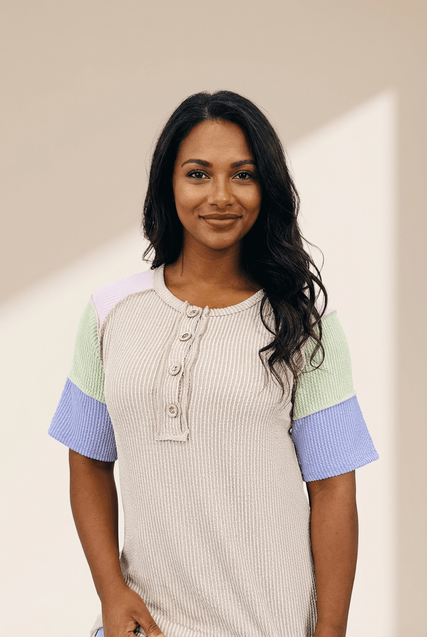 Woman wearing a colorful shirt with a neutral background