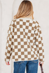 Person wearing a checkered sweater with a neutral background.
