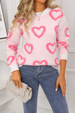 Person wearing a pink sweater with heart patterns and blue jeans, holding a beige handbag.