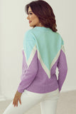 Woman wearing a colorful sweater with a geometric pattern on a white background