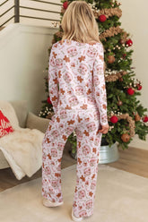 Back view of woman in long-sleeve pajamas with allover Christmas print.