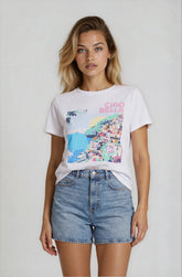 Woman wearing a white t-shirt with colorful graphic and 'Ciao Bella' text, paired with denim shorts on a plain background.