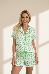 Woman wearing a green and white patterned pajama set on a beige background