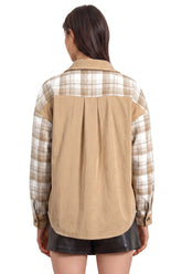 Back view of woman in tan corduroy and beige-white plaid shirt with black shorts.