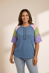 Woman wearing a colorful shirt with a plain background