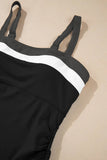 Black swimsuit with white trim on a beige surface