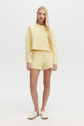 Woman wearing a yellow outfit on a white background