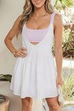 Woman wearing a white dress over a purple checkered top outdoors.