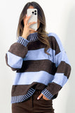 Woman in chunky light blue-brown striped sweater with dark brown pants, mirror selfie.