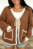Woman in chestnut knit cardigan with cream trim, tie front and patch pockets, front view