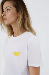 Woman wearing a white t-shirt with a yellow logo against a white background