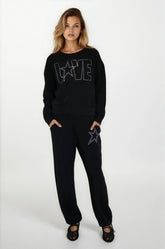 Woman wearing a black outfit with star designs on a white background