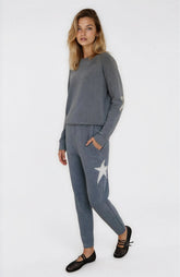 Woman wearing a gray sweatshirt and pants with a star design on a white background