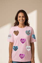 Woman wearing a pink t-shirt with heart-shaped designs and text on a beige background