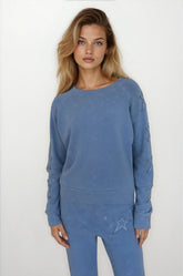 Woman wearing a blue sweatshirt and pants on a white background