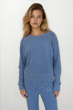 Woman wearing a blue sweatshirt and pants on a white background