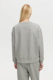 Person wearing a gray sweatshirt and pants on a white background