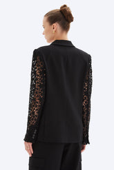Black long-sleeve top with lace detailing on sleeves worn by a model on a white background