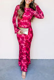 Woman wearing a pink floral dress holding a clutch against a white background