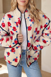 Woman in cream sherpa jacket with red-blue floral print, white top, and jeans.