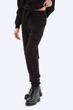 Person wearing black jogger pants and black boots on a white background
