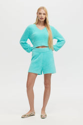 Woman wearing a turquoise outfit on a white background