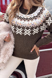 Woman wearing a brown Fair Isle sweater with colorful accents, white pants, and a pink bag.