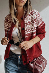 Woman in red and cream patterned knit cardigan, white top, blue jeans and burgundy shoulder bag.