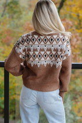 Woman seen from behind in brown Fair Isle sweater with cream-black pattern and light blue jeans.